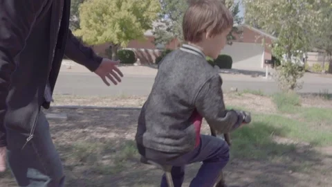 Father teaching his son how to ride his bike on a cool afternoon. Video stock 169733718