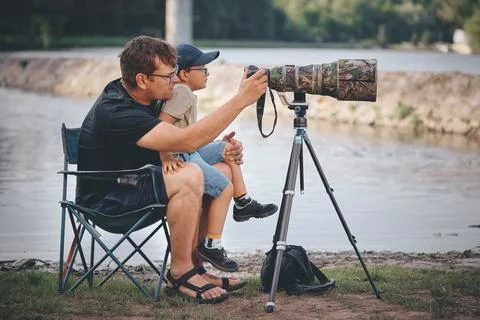 Father teaching his son how to photograph wildlife with a super telephoto len Photos