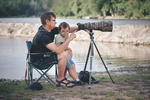 Father teaching his son how to photograph wildlife with a super telephoto len Photos