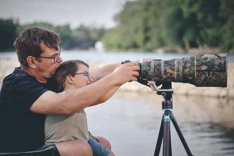 Father teaching his son how to photograph wildlife with a super telephoto len Photos