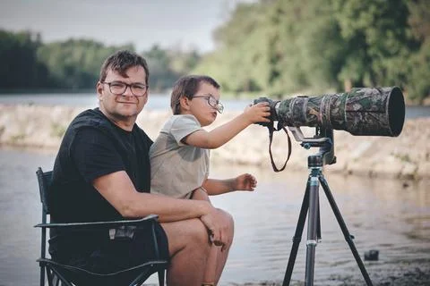 Father teaching his son how to photograph wildlife with a super telephoto len Photos