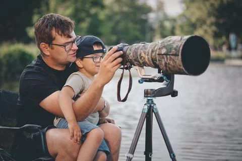 Father teaching his son how to photograph wildlife with a super telephoto len Photos
