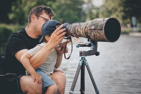 Father teaching his son how to photograph wildlife with a super telephoto len Photos