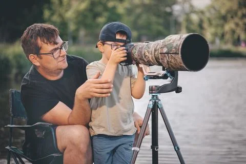 Father teaching his son how to photograph wildlife with a super telephoto len Photos