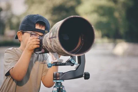 Father teaching his son how to photograph wildlife with a super telephoto len Photos