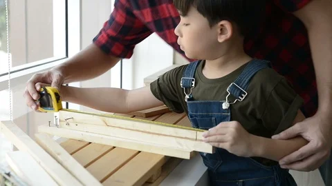 Father teaching his son to use a tape measure on a work plank wood. Stock Footage 109119670