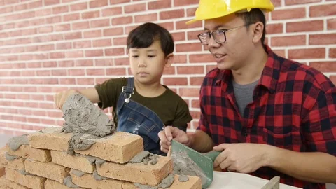 Father teaching his son use trowel and masonry with family holiday Vidéo 115521087