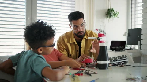 Father teaching kids about STEM, robotics, and discussing technology. Stock Footage 310209028