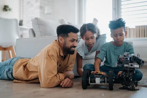 Father teaching kids about STEM, robotics, and discussing technology. Stock Photos