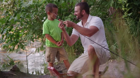 Father teaching son how to bait and fish Stock-Footage 67299281