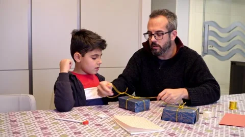 Father teaching son preparing Christmas presents Stock Footage 345253340