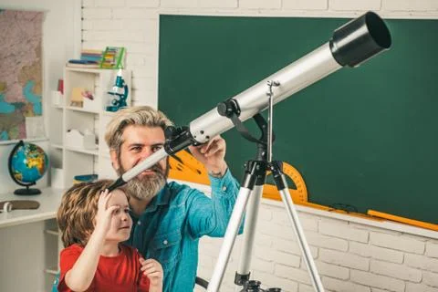 Father teaching son. Pupil watching stars with a teacher and hold Astronomy Stock Photos