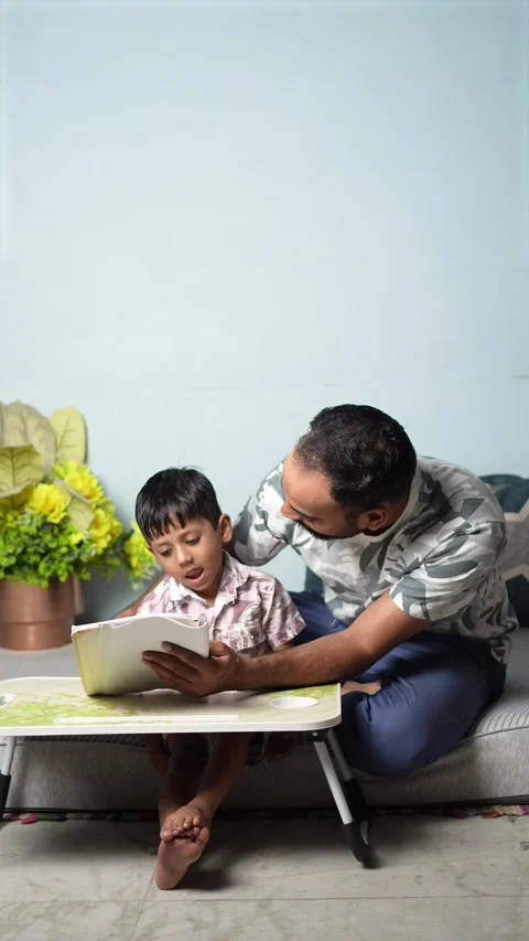 Father Teaching Son to Read at Home, Delhi Stock Footage 339484419