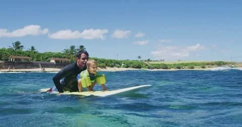 Father teaching son to surf tandem surfing Stock Footage 77640570