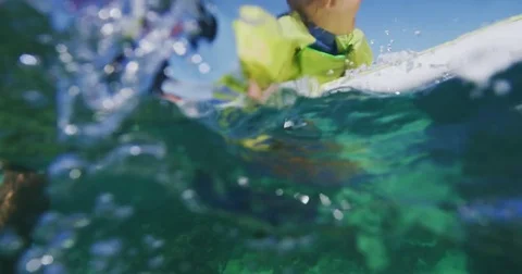 Father teaching son to surf tandem surfing Stock Footage 77640684