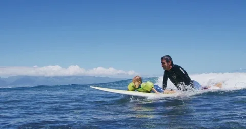 Father teaching son to surf tandem surfing Stock Footage 77640983