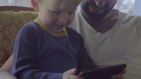 Father teachs boy to use mobile phone Stock Footage 64401754