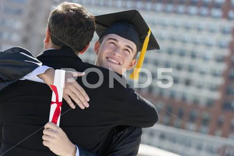 Father with teenage sun (16-17) at graduation ceremony Stock Photos