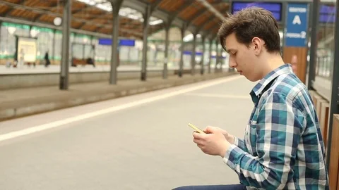 Father texting sms on smartphone while his son is walking on the platform Stock Footage 76039480