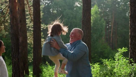 Father Throwing Daughter Up While Sister Watches Happily In Forest Stock Footage 321542987