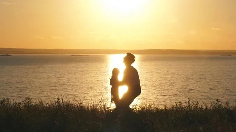 Father throwing his kid up in the air on the beach at sunset Stock Footage 77166334