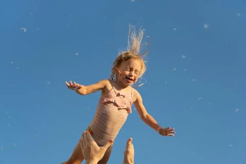 Father throwing up two year old caucasian blonde girl,playing.Dad and daughter Stock Photos