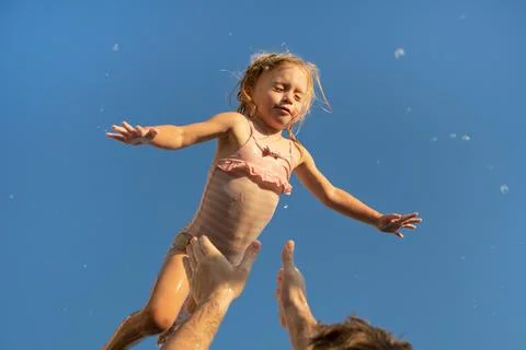 Father throwing up two year old caucasian blonde girl,playing.Dad and daughter Stock Photos