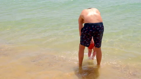 Father throws up the baby on the beach. selective focus. Stock Footage 154345459