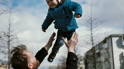 A father throws up a happy little son. parent playing with child.Family game Stock Footage 235640080