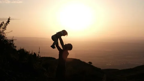 Father throws his son into the air at sunset in the highlands 库存影片 230604208