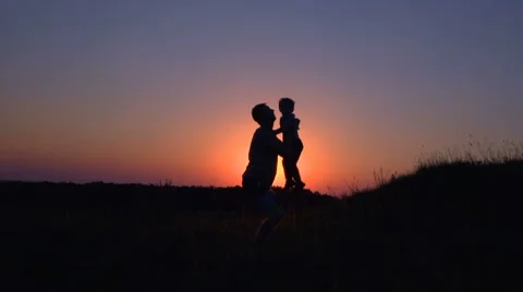 Father throws up son at sunset Stock Footage 64709487