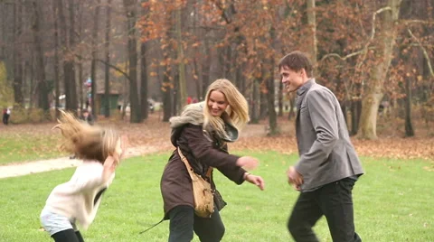Father trying to catch daughter while she's hiding behind mother Stock Footage 59554076