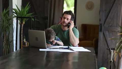 Father is trying to work and play with a little boy at same time at home. Stock Footage 135279765