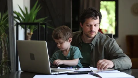 Father is trying to work and play with a little boy at same time at home. Stock Footage 135280152
