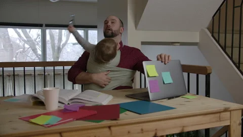 Father trying to work from home while caring for children Stock Footage 145854019