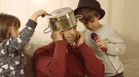 Father is trying to work on lap top, while his children are having fun. Stock Footage 22904927