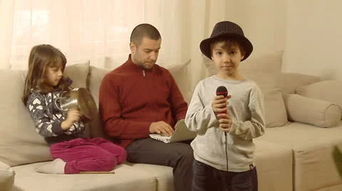 Father is trying to work on lap top, while his children are having fun. Stock Footage 22914578