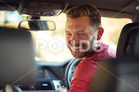 Father Turning Round To Talk To Children In Back Seat On Car Journey Stock Photos
