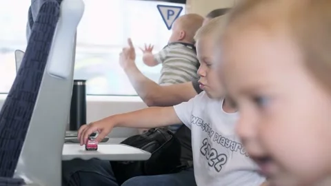 Father with two sons looking out the window at running landscapes. Traveling Stock Footage 220738503
