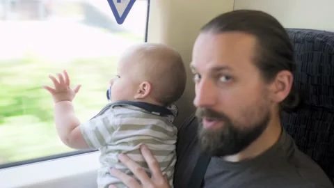 Father with two sons looking out the window at running landscapes. Traveling Stock Footage 220738535