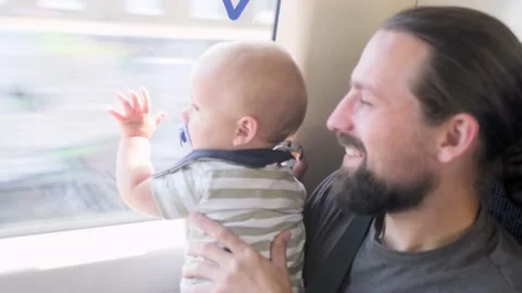 Father with two sons looking out the window at running landscapes. Traveling Stock Footage 220738682
