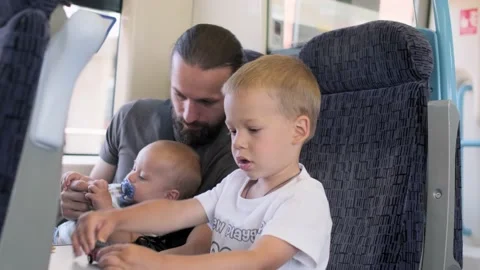 Father with two sons looking out the window at running landscapes. Traveling Stock Footage 220738747