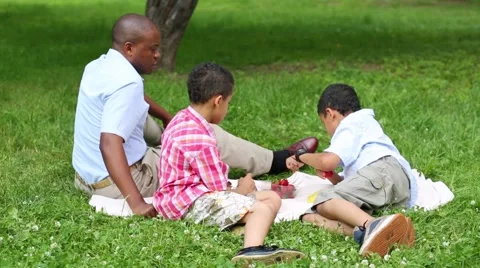 Father with two sons rest in summer park and eating strawberries Stock Footage 45859137