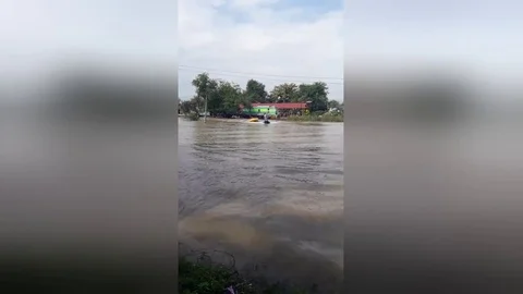 Father using jet ski to pull children on dingy during flood Video stock 109251923