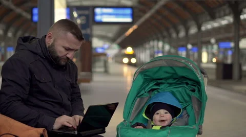 Father using laptop on station wait with son Stock Footage 60662507