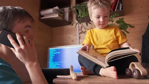 Father work home, talks on smartphone, child read book, parenthood multitasking Video stock 130494841