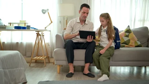 The father is working on a digital tablet from his sofa at home, Stock Footage 340908822