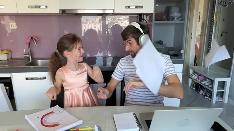 Father working from home getting interrupted by his playful daughter Stock Footage 309302653