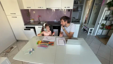 Father working from home while taking care of his daughter Stock Footage 309302023