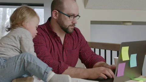 Father working remotely while caring for children Stock Footage 145854058